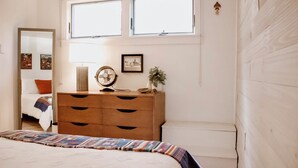 A bedroom with a bed, dresser, and windows. - Stylish Douglas Retreat - Steps from Dunes Resort! (Douglas)
