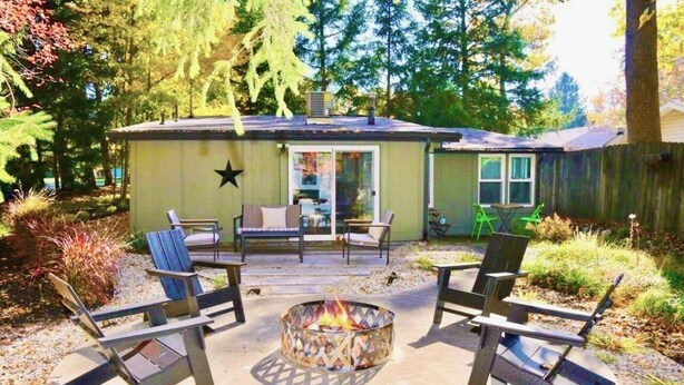 A small cabin with a fire pit in the center, surrounded by outdoor seating. - Stylish Douglas Retreat - Steps from Dunes Resort! (Douglas)