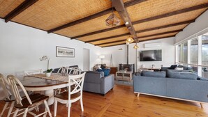 A spacious living area with a dining table, sofas, and a fireplace. - Paradise Retreat Lakehouse  - Jamieson - Sleeps 10 (Jamieson)