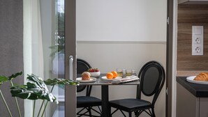 Ein moderner Essbereich mit einem Tisch für zwei Personen, mit einem Croissant, Obst und Orangensaft.