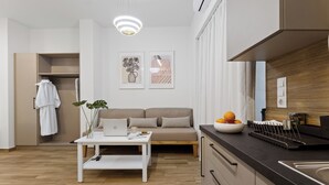 Eine moderne Küche mit Holzausziehtisch, Spüle und einem Essbereich mit weißem Tisch und einer Couch.