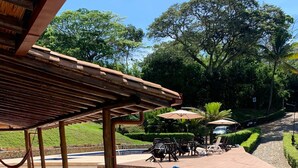 A covered outdoor area with steps leading to a pool, surrounded by greenery and a car parked nearby. - VILLA CATALINA FARM WITH SWIMMING POOL AND JACUZZI NEAR LA PINTADA  (Santa Bárbara)