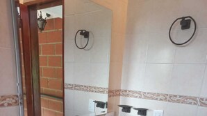 A bathroom with a white sink, wooden vanity, and a mirror. - VILLA CATALINA FARM WITH SWIMMING POOL AND JACUZZI NEAR LA PINTADA  (Santa Bárbara)