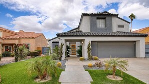 A modern two-story house with a front garage, a well-maintained lawn, and a variety of desert plants. - Desert Scarif Private Pool Hot Tub Putting Green Near Coachella Festivals (Indio)
