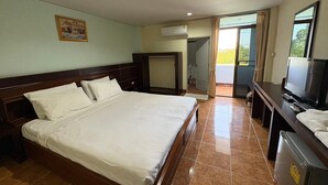 Habitación de hotel con una cama grande, televisión, escritorio y balcón con vistas.