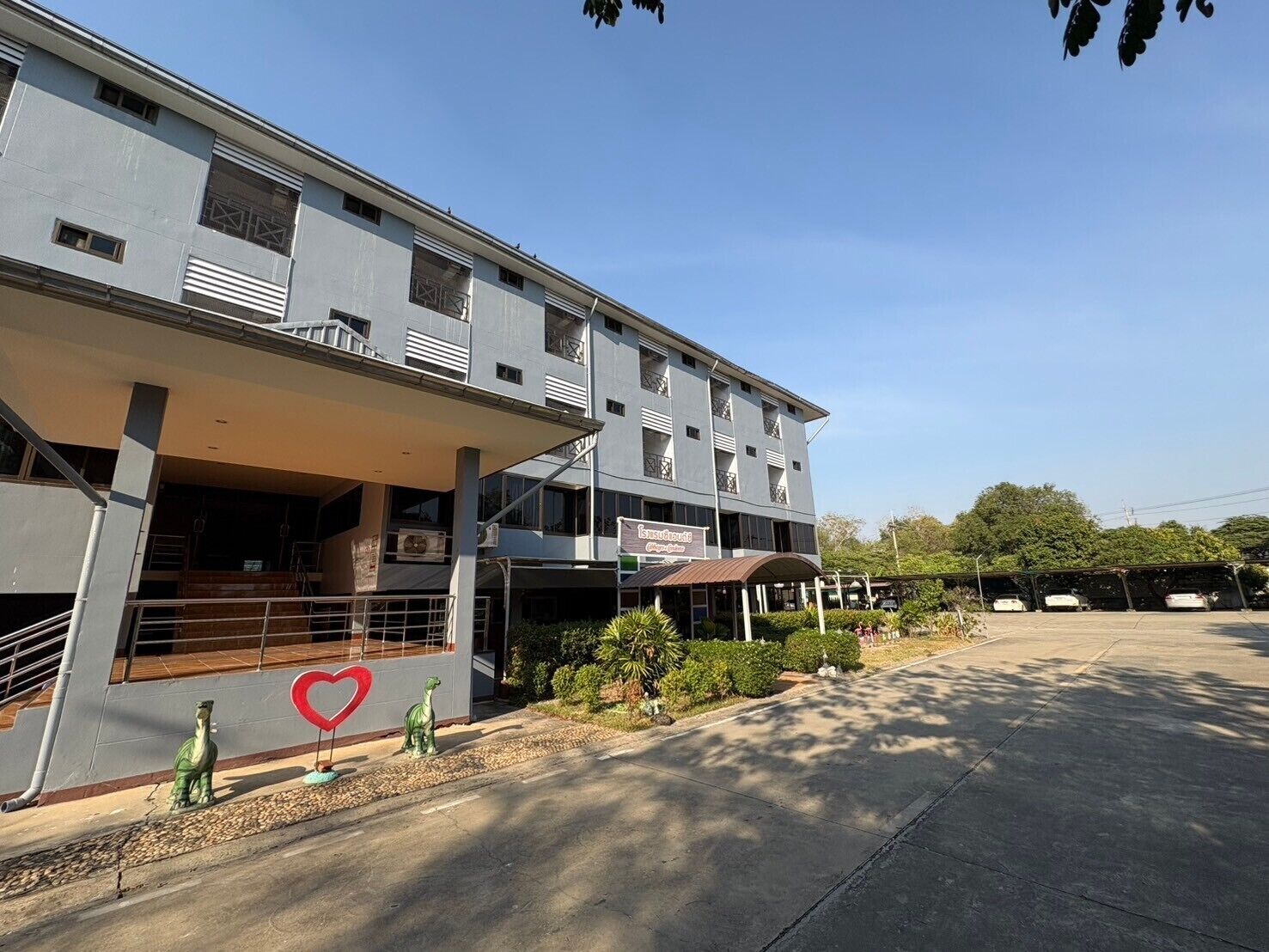A multi-story building with a covered entrance and a heart-shaped decoration on the facade.