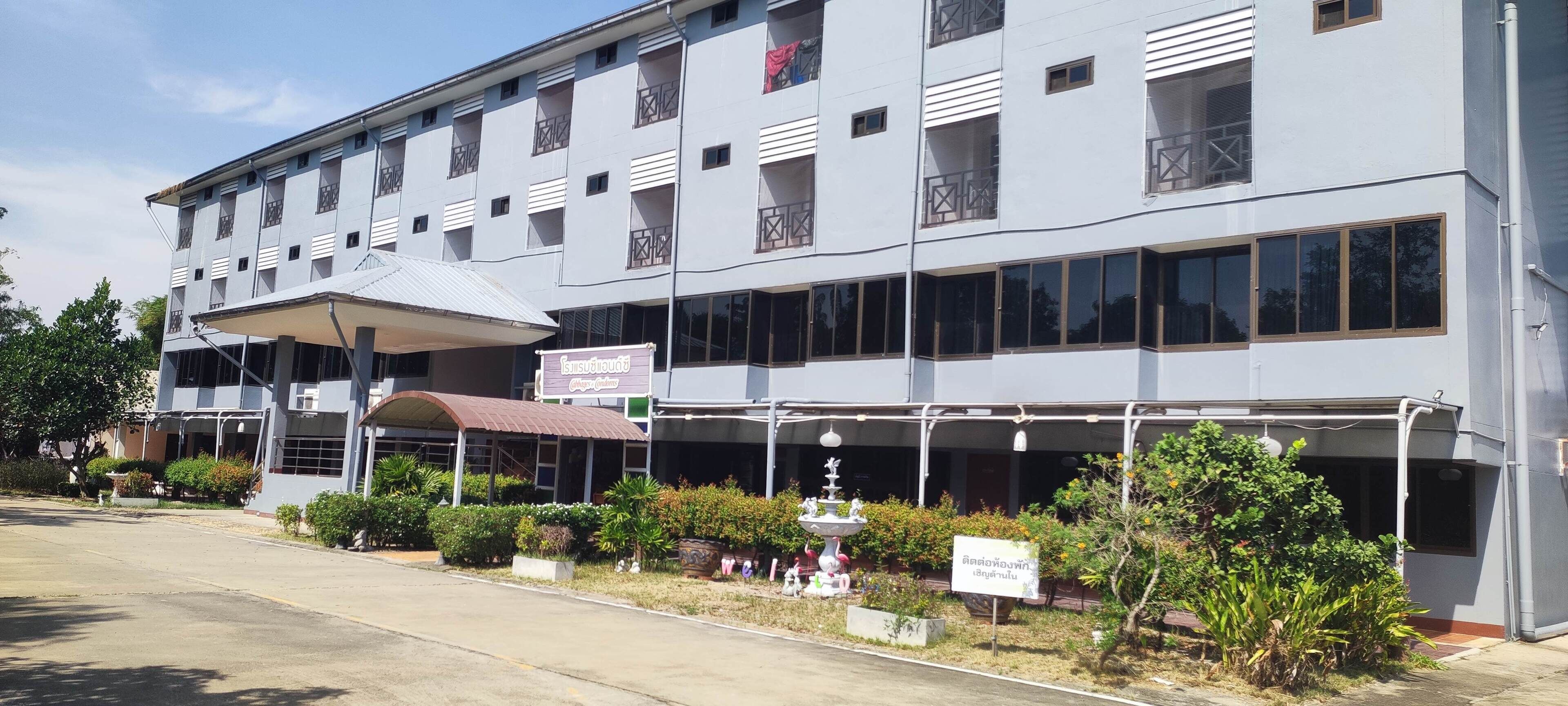 A multi-story hotel with a covered entrance and outdoor seating area.