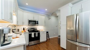 A modern kitchen with white cabinets, stainless steel appliances, a wooden floor, and a small island with a sink. - National Harbor  Hideaway - Oasis /Jacuzzi w/ 4-bedroom/3-Bath  
Fort Washington (Fort Washington)