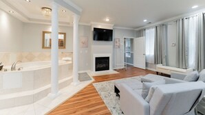 A modern living room with a fireplace, a large white sofa, and a bathtub. - National Harbor  Hideaway - Oasis /Jacuzzi w/ 4-bedroom/3-Bath  
Fort Washington (Fort Washington)