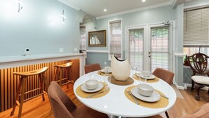 A dining area with a round table set for four, wooden bar stools, and a decorative vase centerpiece. - National Harbor  Hideaway - Oasis /Jacuzzi w/ 4-bedroom/3-Bath  
Fort Washington (Fort Washington)