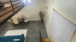 Un interior moderno con una escalera, un comedor y una lámpara en el techo.