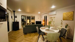 Un salon moderne comprenant un canapé, une table à manger, des chaises et un téléviseur.