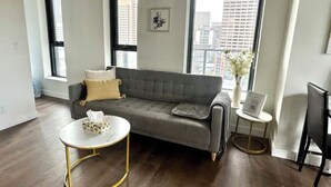 A modern living room with a grey sofa, a round coffee table, and a small side table. - *Cozy Condo/King Bed/Pool/Gym/CityViews/Walkscore 91 (Calgary)