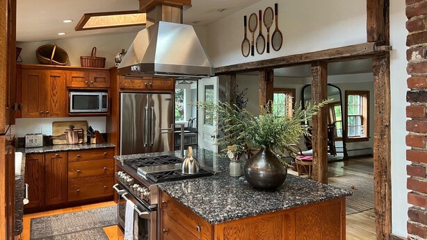 A modern kitchen with wooden cabinets, stainless steel appliances, and a granite countertop. - Historic Edge of the River, Adirondacks (Willsboro)