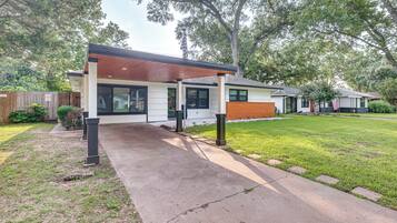 A modern two-story house with a covered patio and a well-maintained lawn.