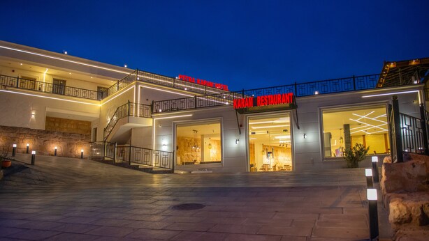 Un hotel dal design moderno, con un ingresso ben evidente, un balcone al secondo piano e un cartello pubblicitario per il ristorante.