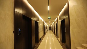 A long, well-lit hallway with marble flooring and modern doors, leading to multiple rooms. - Afal Suites Al Yarmouk (Riyadh)