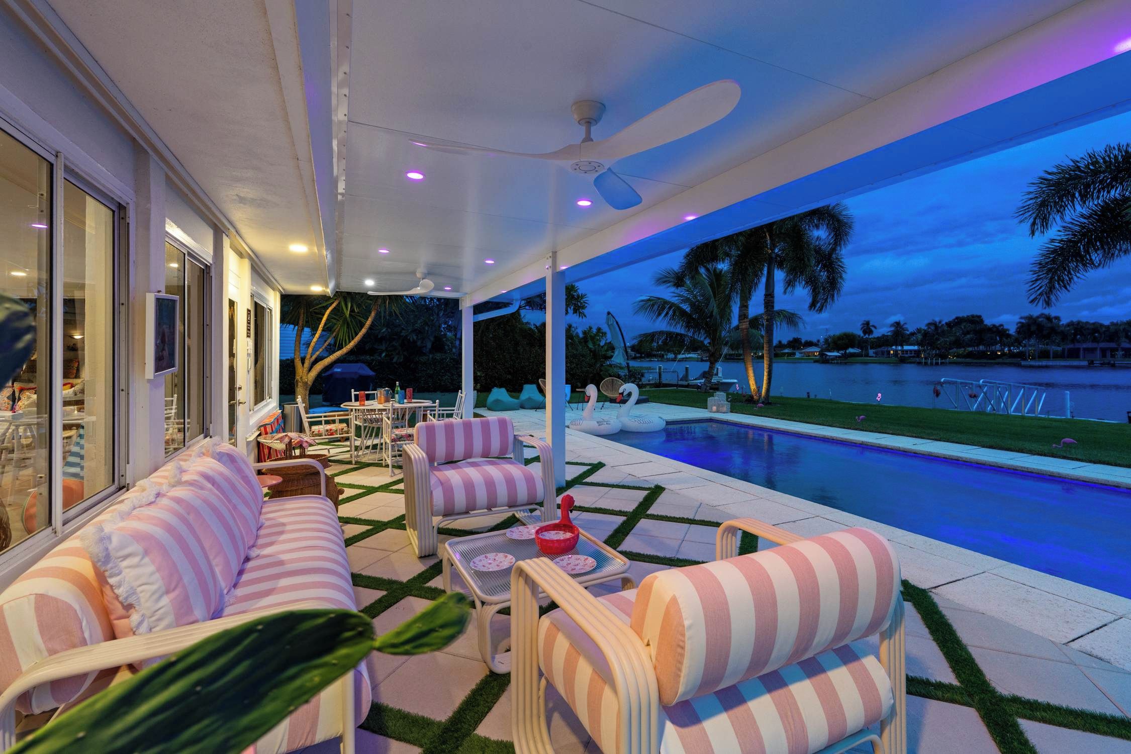 Un patio exterior con piscina, sillas de descanso y vistas al agua.