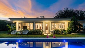 A modern house with a swimming pool, two white chairs, and a flamingo statue. - The Clarke Collection-Villa Flamingo - Waterfront (Lake Clarke Shores)