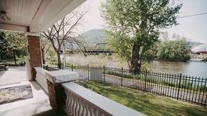 Ein Balkon mit Blick auf einen Fluss, eine Brücke und Bäume.