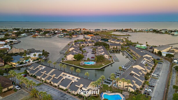 A coastal residential area with houses, a marina, and a swimming pool.
