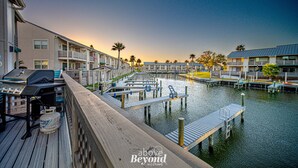 A waterfront hotel with multiple balconies, a dock, and a marina. - The Salty Seahorse | Pet-Friendly Canal Retreat w/ Grill & Deck (Rockport)