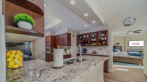 A modern kitchen with granite countertops, wooden cabinets, and a built-in oven.