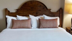 A bed with a wooden headboard, white bedding, and two patterned pillows. - Spring Break in Breckenridge! Ski in/out on Peak 7 (Breckenridge)