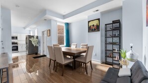 A modern kitchen with white cabinets, a stainless steel refrigerator, and a blue curtain.