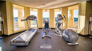 Une salle de sport équipée d’un tapis de course, d’un vélo elliptique et d’un vélo d’appartement, de grandes fenêtres offrant une belle vue et d’un plafond doté d’un éclairage encastré.