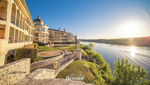 A waterfront hotel with a large building featuring arched balconies and a dome structure. - Island Summer Sunrises | Spa | Eats | Last Minute Deals! (Lago Vista)
