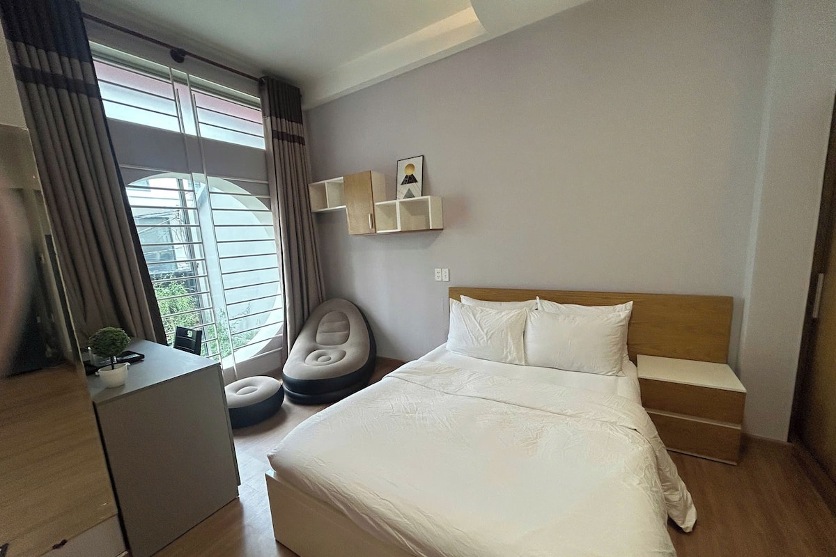 Um quarto moderno com uma cama grande, uma escrivaninha e uma cadeira.