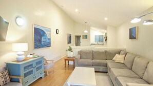 Ein Wohnzimmer mit einer Couch, einem Couchtisch, einem blauen Schrank und einer Lampe.