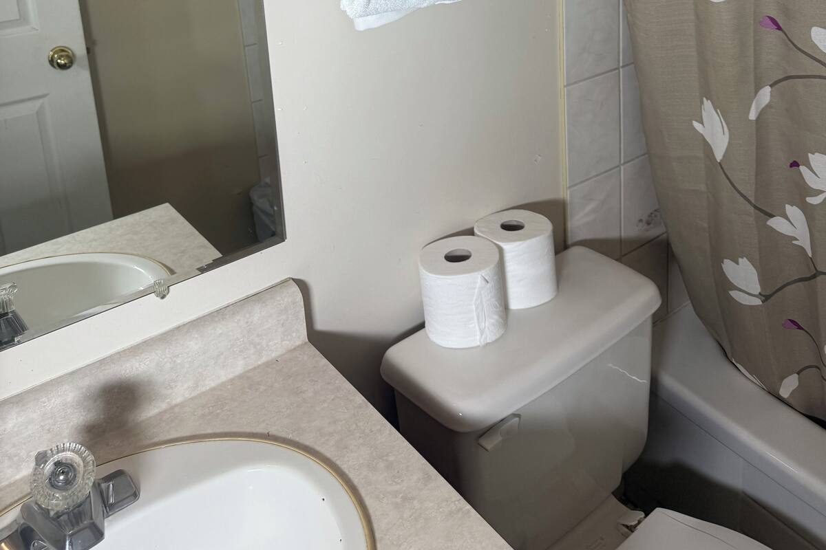 Et badeværelse med vask, toilet og håndklædestang.
