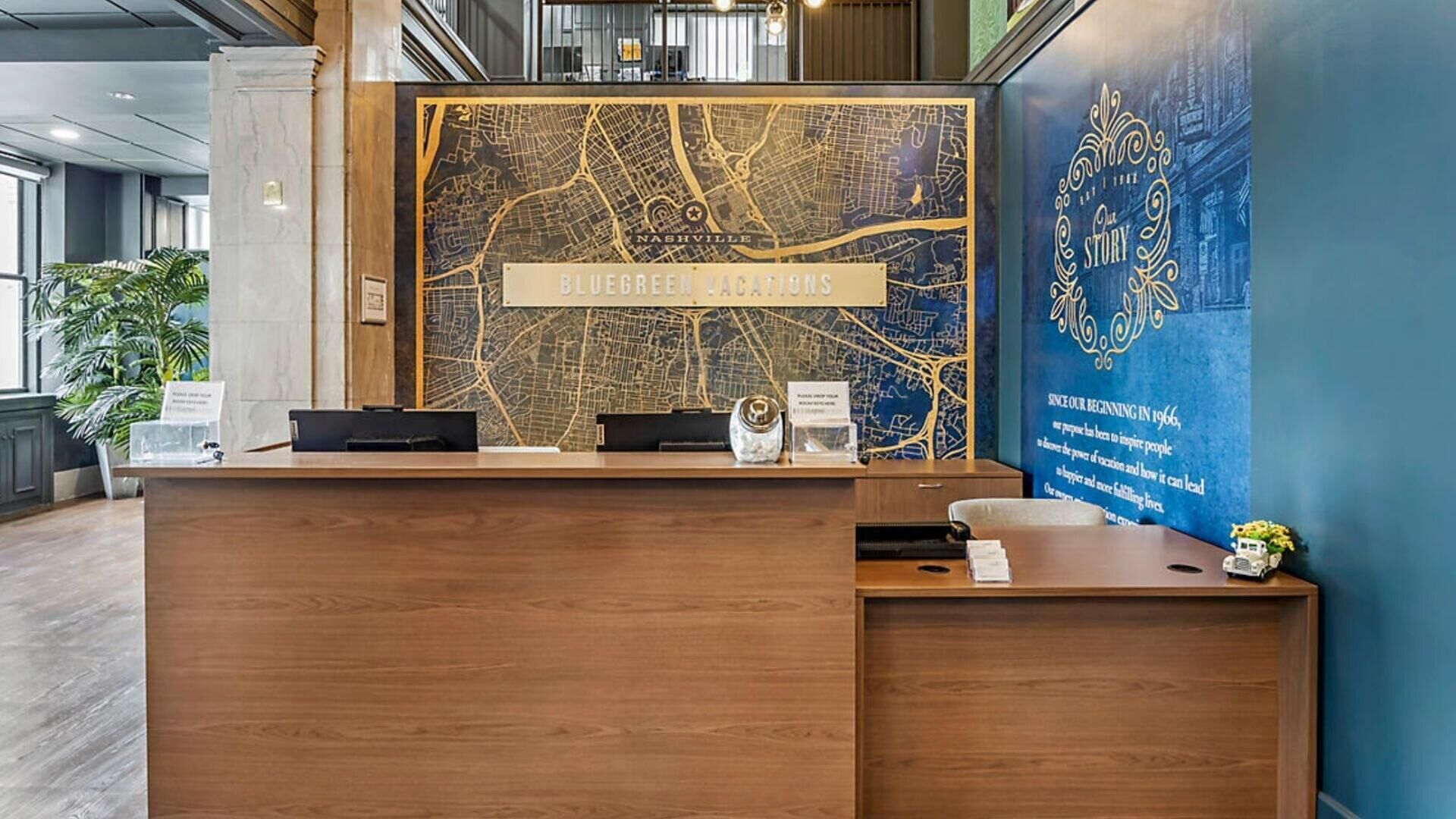 Un mostrador de recepción con un mapa de Nashville, un letrero que dice 'BIEGREEN LOCATIONS' y una gran pared azul con texto.