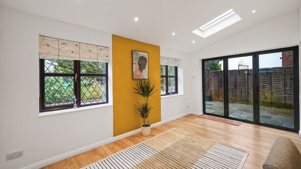 Une pièce spacieuse avec de grandes fenêtres, une plante en pot et un design moderne au niveau du plafond.