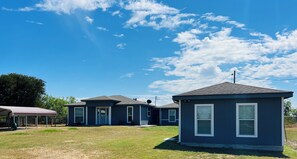 A residential area with houses, a covered structure, and a clear sky.
