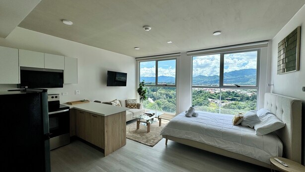 Una habitación moderna con cocina, comedor y cama con vistas.