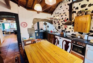 Une cuisine rustique avec un mur en pierre, des meubles en bois et une arche en pierre.