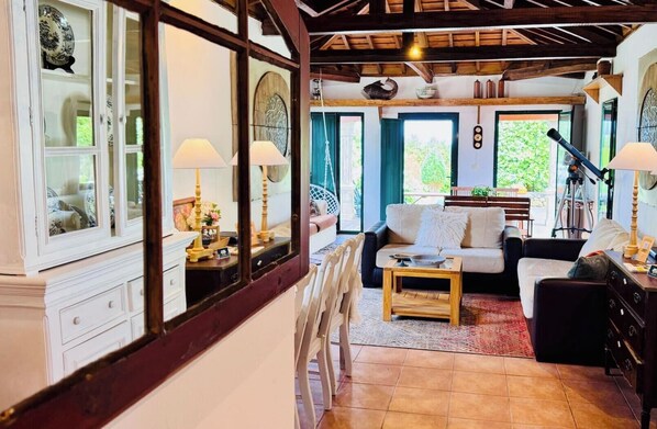 Un salon chaleureux avec un canapé, des fauteuils, une table basse et un meuble avec des portes en verre.
