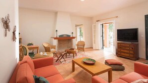 A living room with a fireplace, sofas, a TV, and a dining area. - Attractive Villa, A/C, Large Private Pool & Idyllic Setting in the Sought-After Area of Gastouri! (Kerkira)