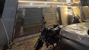 A hotel with a sign reading "Kings Court Hotel" and a contact number. There is a motorcycle parked in front. - KINGS COURT HOTEL  (New Delhi)