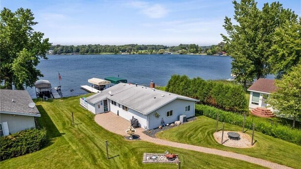 A house with a dock, a lawn, and a view of a lake. - Tradewinds Cabin on Big Cormorant (Audubon)