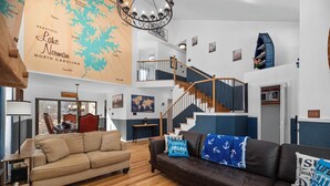 Un salón espacioso con un mapa grande, una escalera y una zona de estar acogedora.
