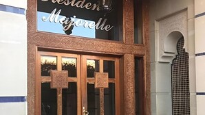Entrada de un edificio con un letrero que dice 'Résider Majesté'.