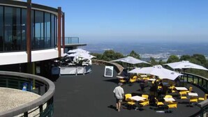 Une terrasse sur le toit avec des sièges extérieurs, une vue sur la ville et une architecture moderne.