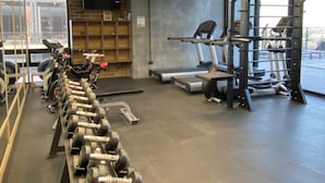 A gym with exercise equipment, including dumbbells and treadmills.