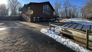 A large wooden building with a stone wall and a wooden deck. - Large, Family-Friendly Lake Home, On Snowmobile/ATV Trails, W/D, Firepit (Harshaw)