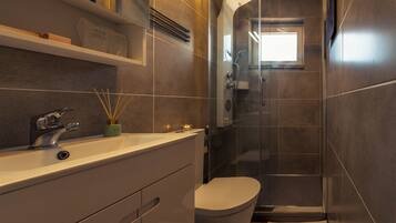 Une salle de bain moderne avec une douche à parois de verre, un lavabo blanc et des toilettes.