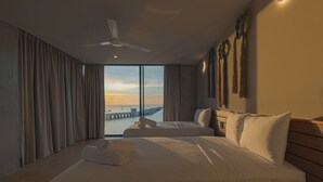 A hotel room with two beds, a ceiling fan, and a view of a pier and water. - Hotel UNNU (Santa María Huatulco)